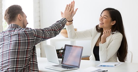 employees high-fiving at team meeting